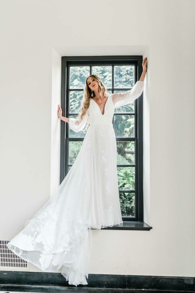 a sheer white wedding dress with long sleeve from Versailles Atelier Bridal