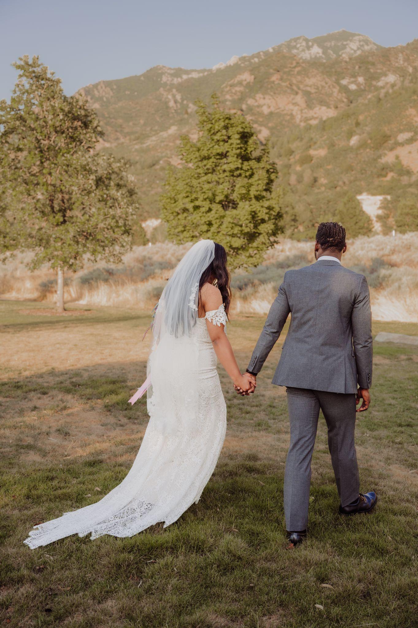 bride and groom walking outside by the mountains