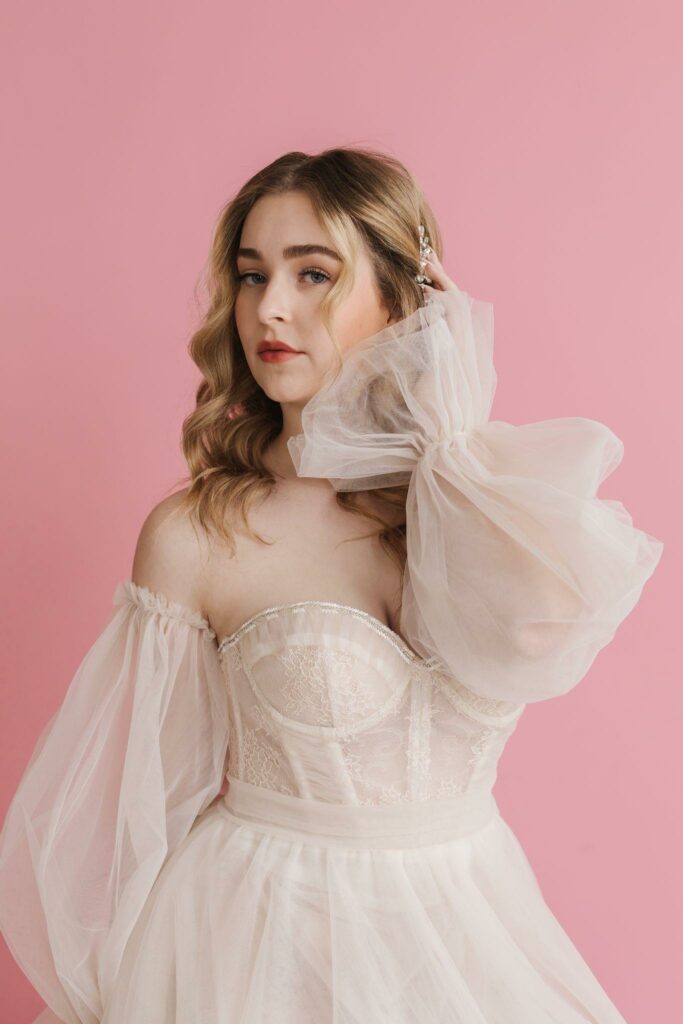 beautiful bride in her simple wedding dress against the pink wall