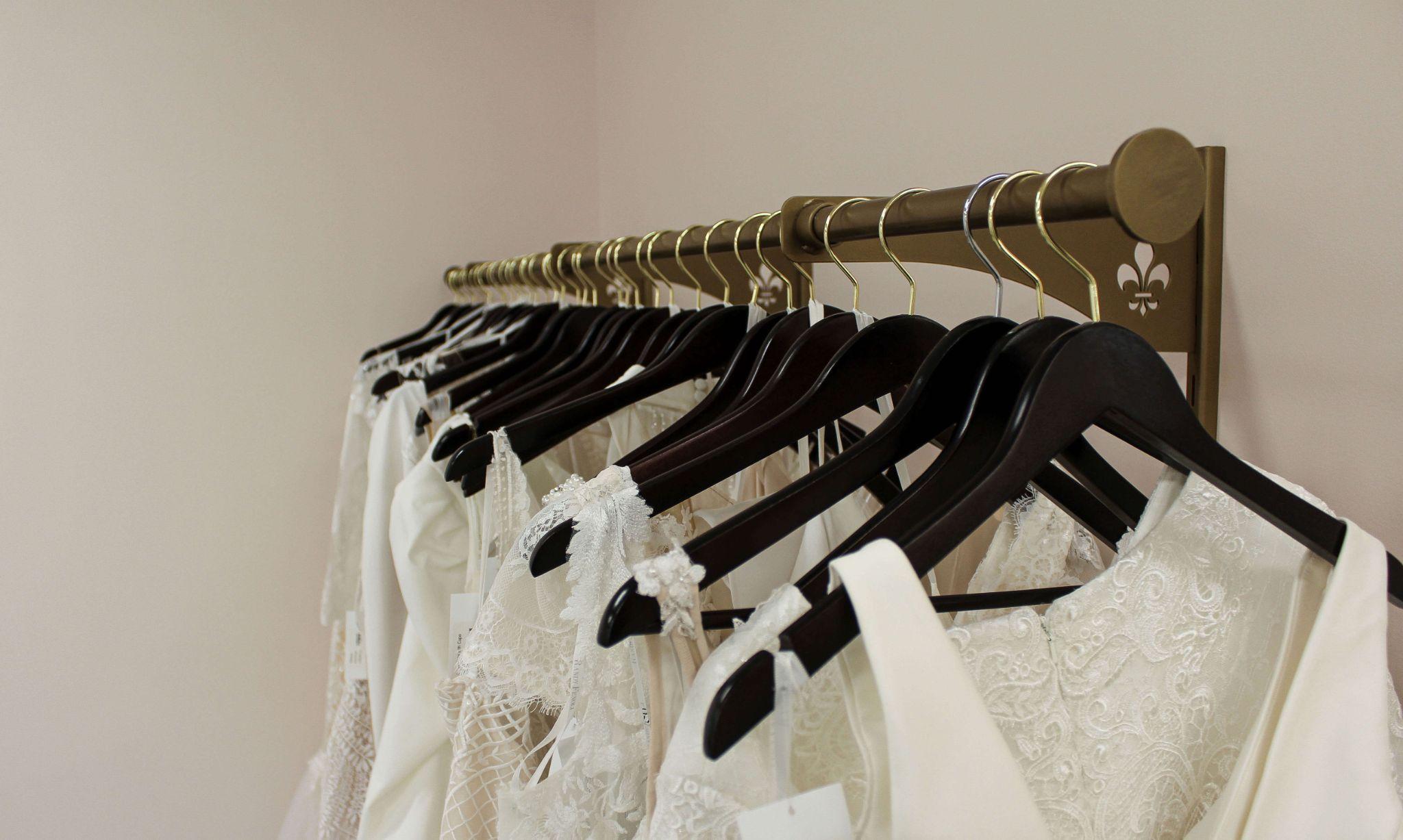 wedding gowns hanging from a clothes rack at a bridal shop