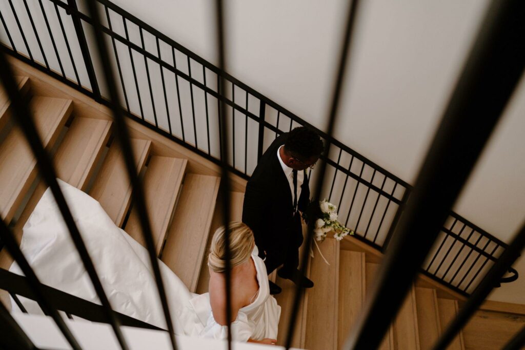 a bride and groom walking down the stairs