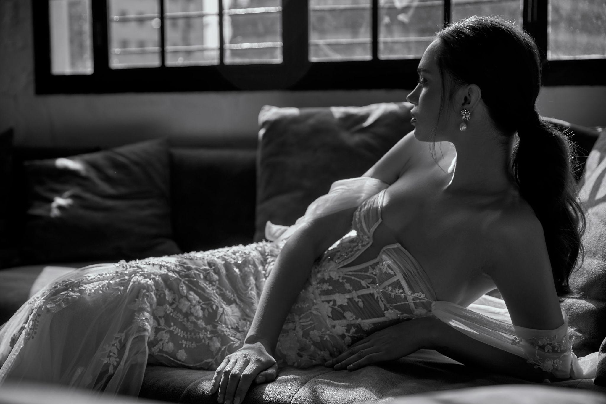 a black and white photo of a woman in body-hugging wedding gown
