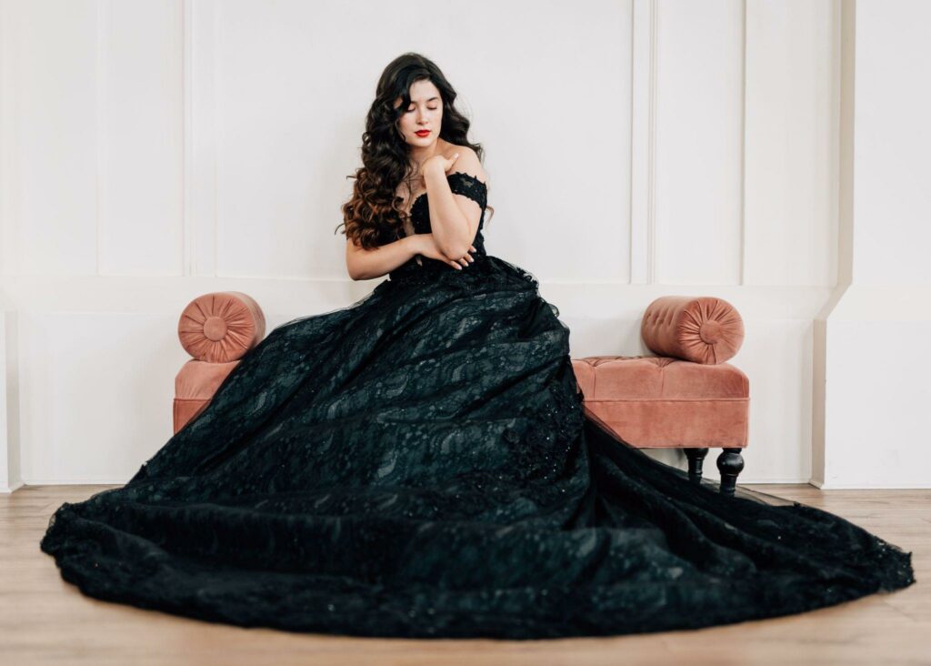 a woman in a black wedding gown sitting on the couch