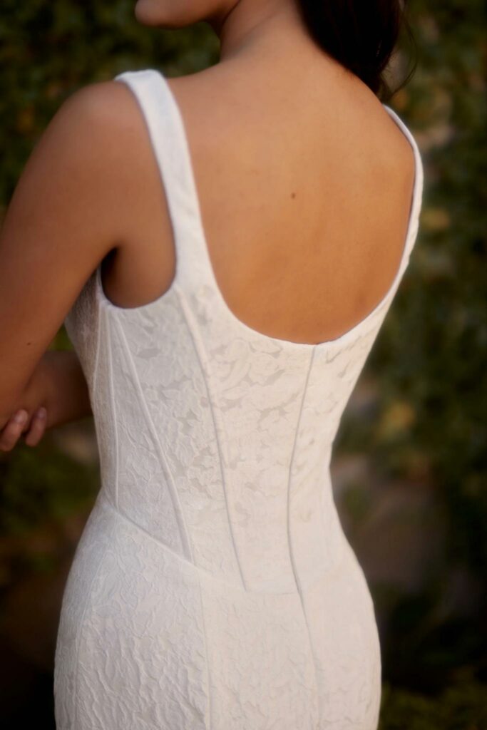 back view of a fitted bridal gown with flower designs from Enaura Bridal