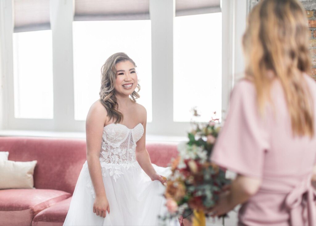 A smiling bride looks down at her bouquet